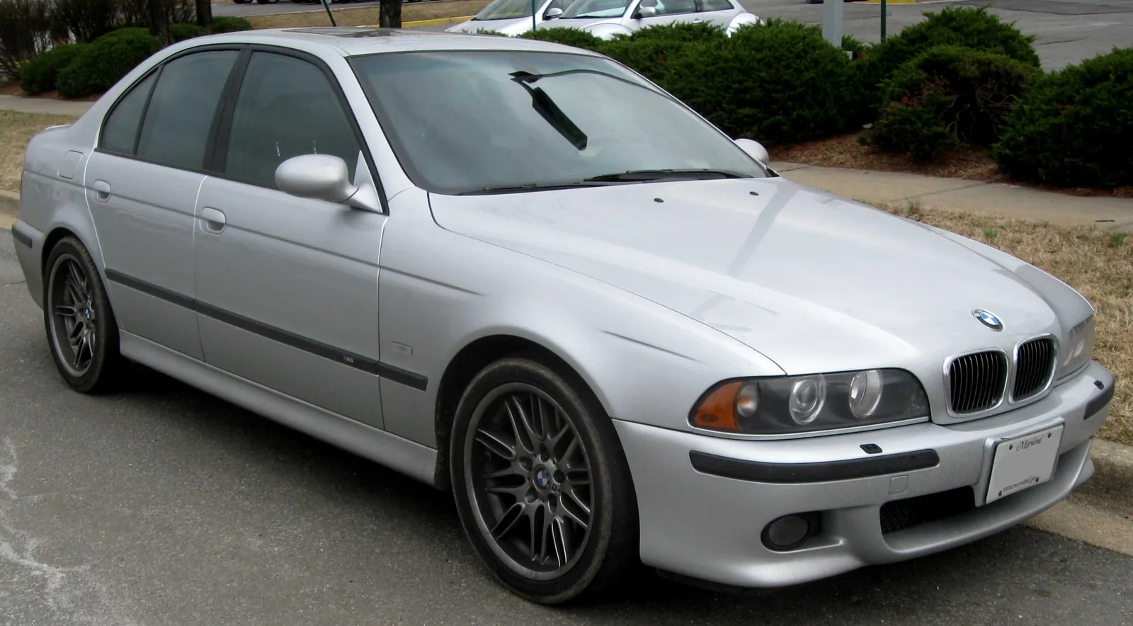 Silver BMW M5 E39 sedan parked outdoors, front three-quarter view.